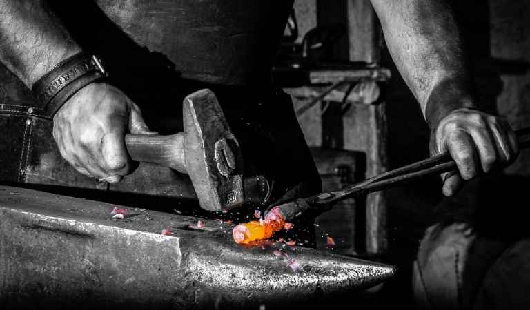 blacksmith hammering metal piece