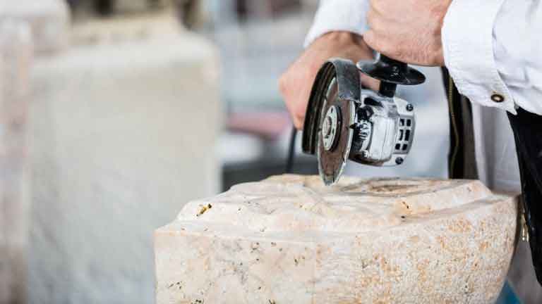 carving wood with angle grinder in shop