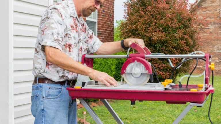 homeowner cutting tile at backyard