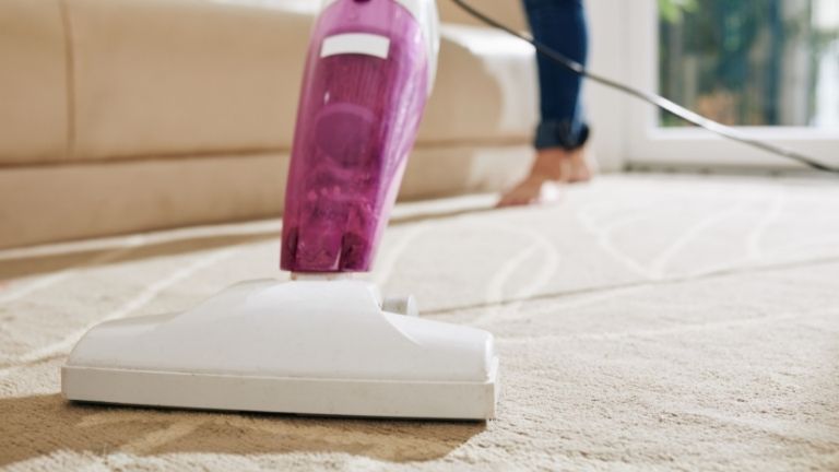 vacuum cleaning carpet in the living room