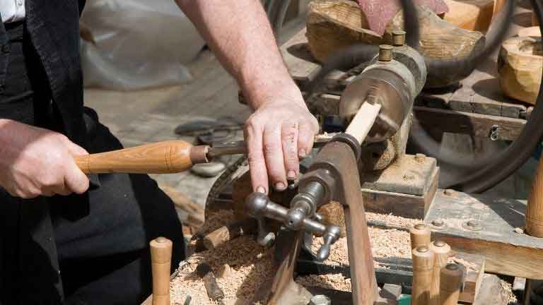 woodworker turning wood with a chisel