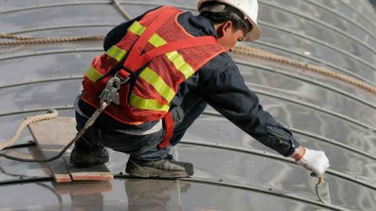 working on ceiling wearing a construction safety harness